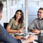 Three people conducting a COA or HOA Reserve Study at a table in an office.